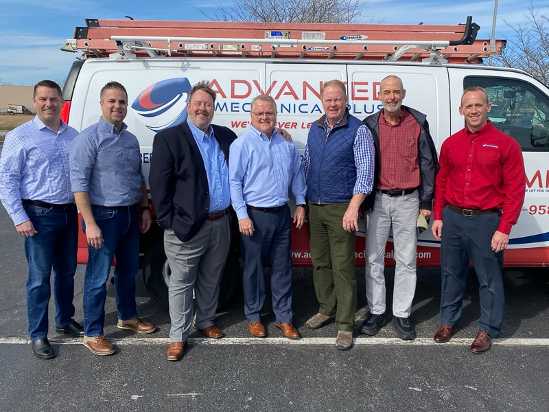 AMP employees standing in front of work van