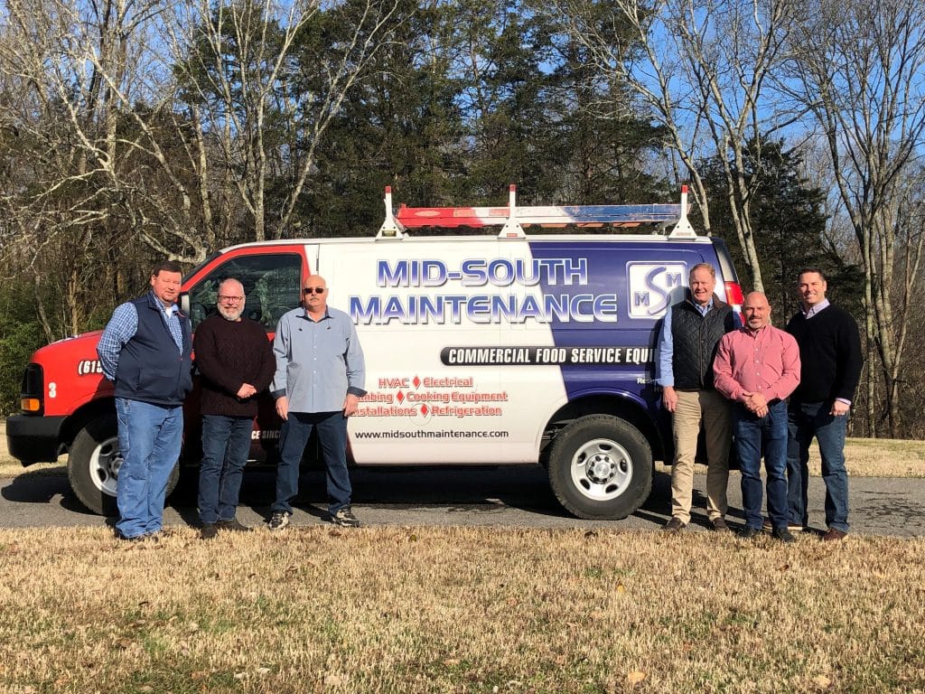 Mid-South Maintenance employees standing in front of work van