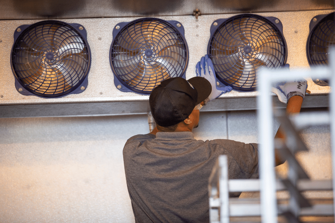 Technician performing walk-in cooler maintenance